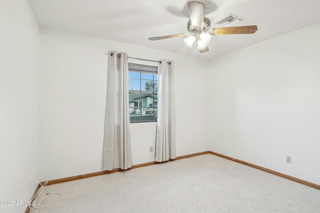 carpeted empty room with ceiling fan and a textured ceiling