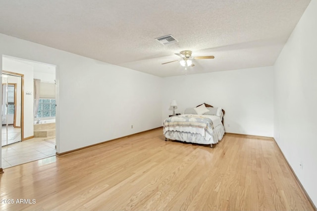 bedroom with ceiling fan, a textured ceiling, and light hardwood / wood-style floors