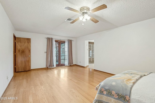 bedroom with french doors, ceiling fan, a textured ceiling, and light wood-type flooring