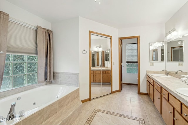 bathroom featuring vanity, tiled bath, and tile patterned flooring