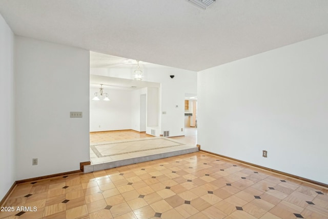 tiled empty room with a chandelier