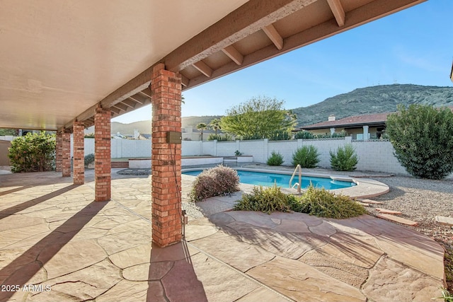 view of patio / terrace featuring a mountain view and a fenced in pool