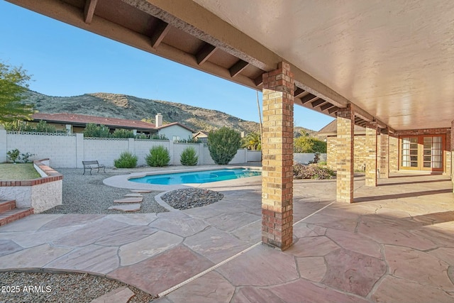 view of patio / terrace featuring a mountain view and a fenced in pool