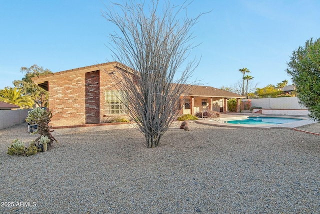 back of house with a fenced in pool and a patio area