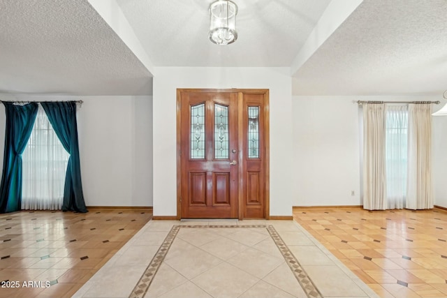 entryway featuring tile patterned flooring, a notable chandelier, and a textured ceiling