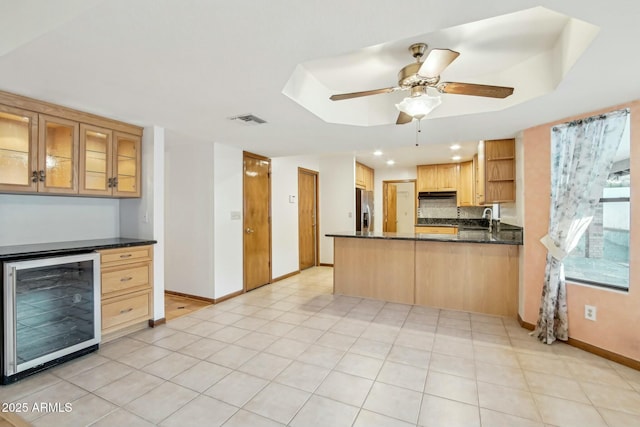 kitchen with sink, stainless steel refrigerator with ice dispenser, wine cooler, decorative backsplash, and kitchen peninsula