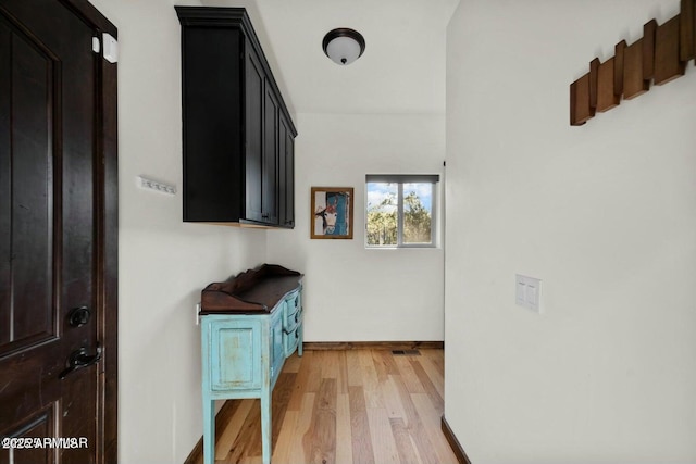 hall with light wood finished floors and baseboards