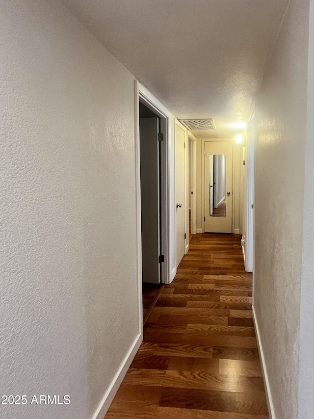 hallway with dark hardwood / wood-style flooring