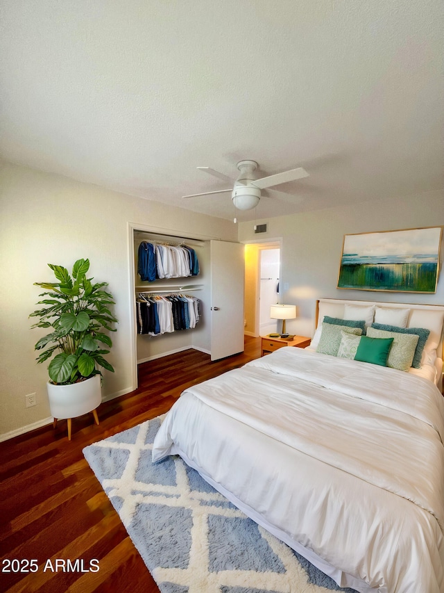 bedroom with dark wood-type flooring, ceiling fan, a closet, and a textured ceiling