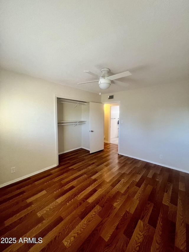 unfurnished bedroom featuring dark hardwood / wood-style floors, a closet, and ceiling fan