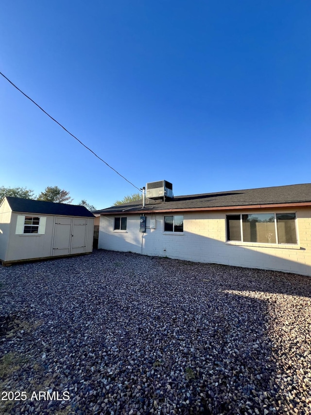 back of property with a shed and central air condition unit