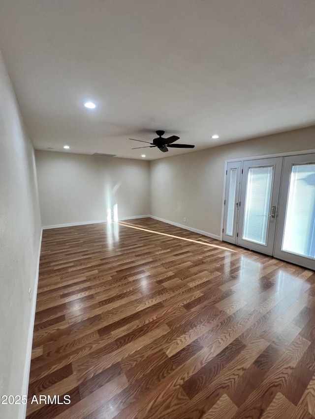 spare room featuring dark hardwood / wood-style floors, ceiling fan, and french doors