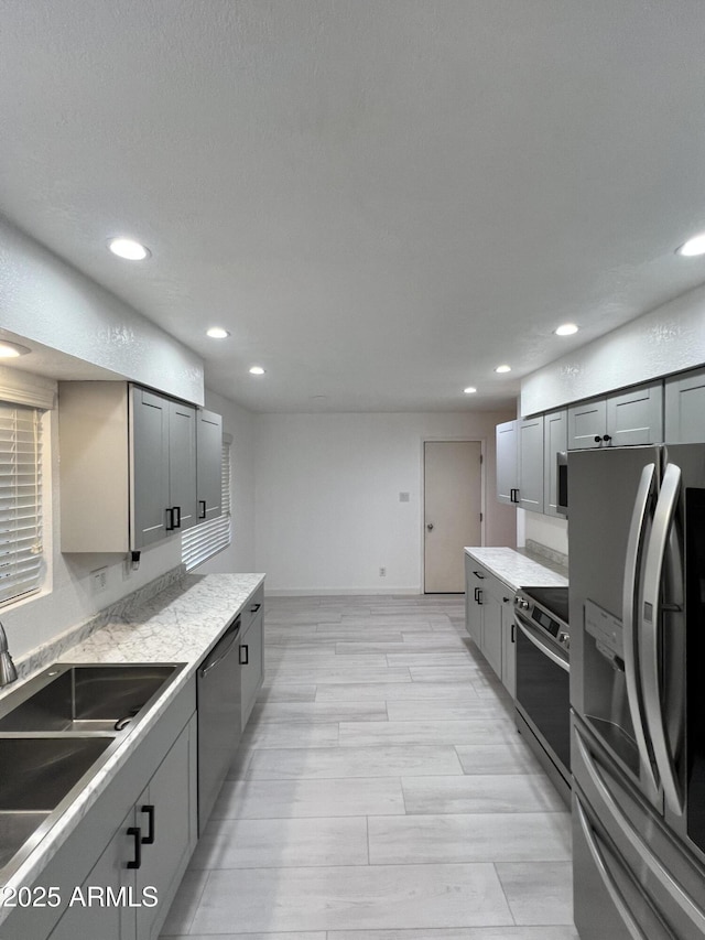 kitchen with stainless steel appliances, sink, and gray cabinetry