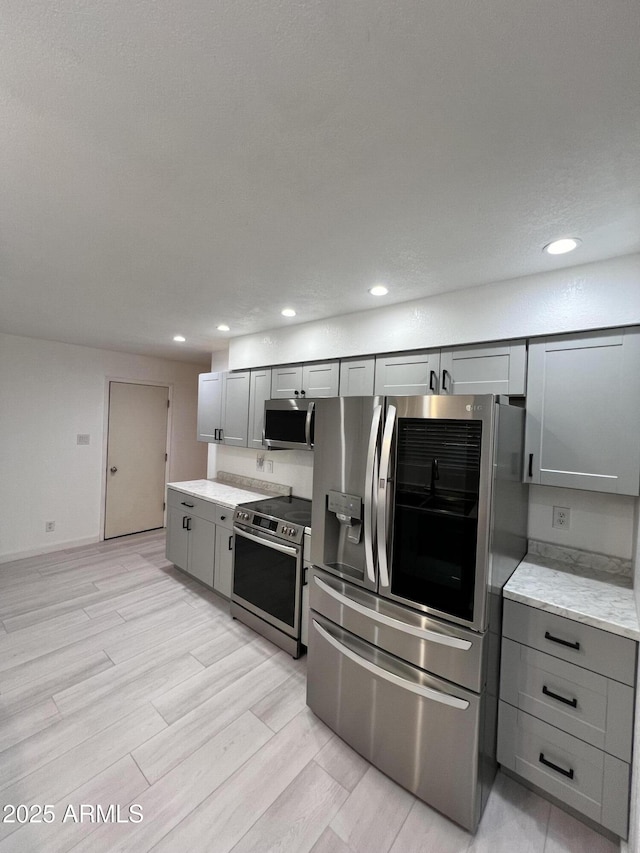 kitchen with appliances with stainless steel finishes and gray cabinetry