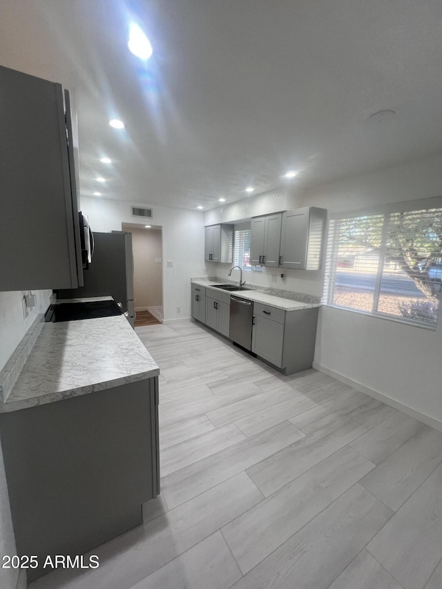 kitchen with sink, gray cabinets, and dishwasher