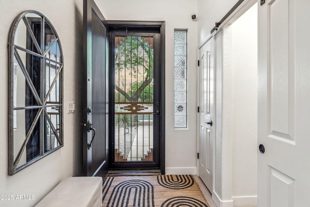 entrance foyer featuring a barn door and baseboards
