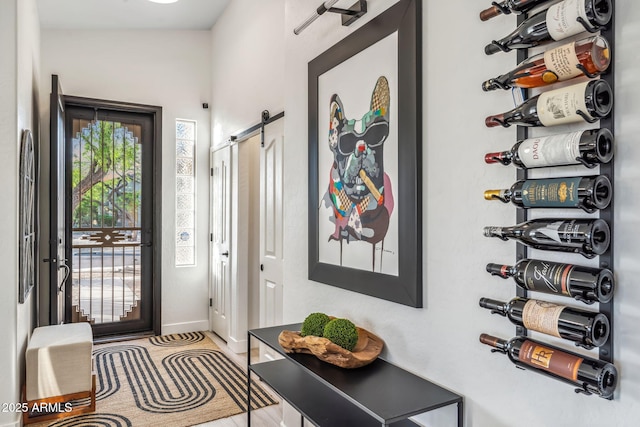 foyer featuring a barn door and baseboards