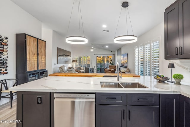 kitchen featuring a sink, visible vents, a peninsula, dishwasher, and open floor plan