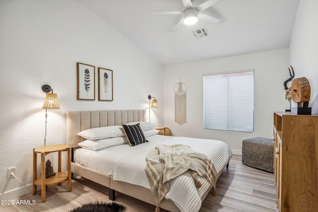 bedroom with lofted ceiling, light wood-style floors, visible vents, baseboards, and a ceiling fan