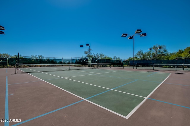 view of tennis court with fence and community basketball court