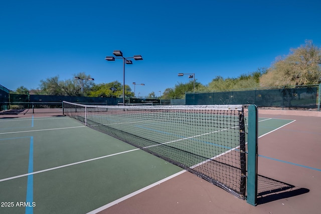 view of tennis court featuring fence