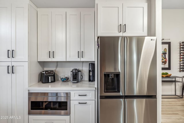 kitchen featuring appliances with stainless steel finishes, white cabinetry, and light countertops