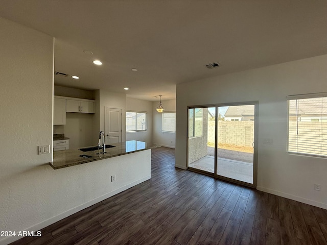 kitchen featuring white cabinets, dark hardwood / wood-style floors, a healthy amount of sunlight, and sink