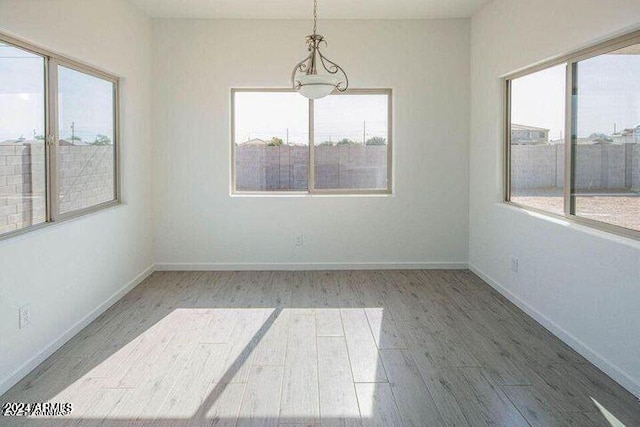 unfurnished room featuring hardwood / wood-style floors and a healthy amount of sunlight