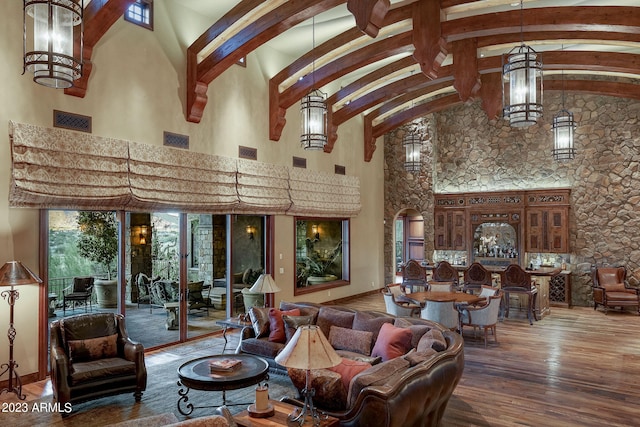 living room with dark hardwood / wood-style flooring, high vaulted ceiling, and beam ceiling