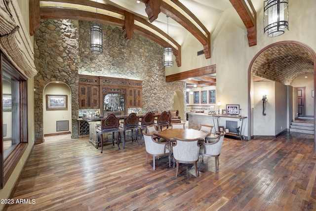 interior space featuring high vaulted ceiling, dark wood-type flooring, and beam ceiling