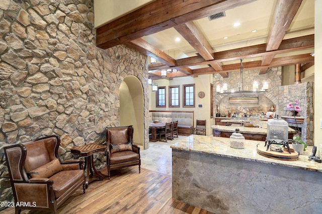 living room with light wood-type flooring, a notable chandelier, beamed ceiling, and coffered ceiling