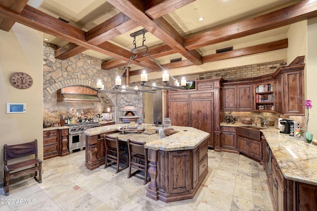 kitchen featuring backsplash, double oven range, and a kitchen island with sink