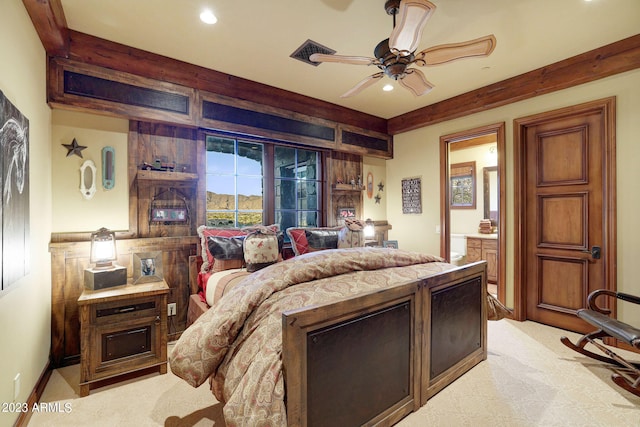 bedroom featuring light carpet, ensuite bath, and ceiling fan