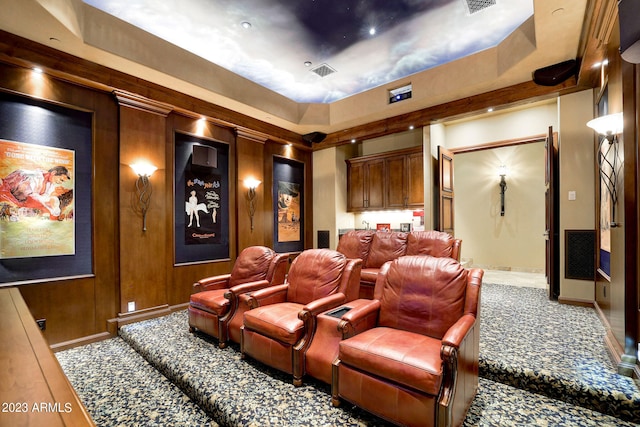 cinema featuring a tray ceiling and carpet