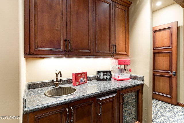 kitchen featuring tile flooring, sink, and dark stone countertops