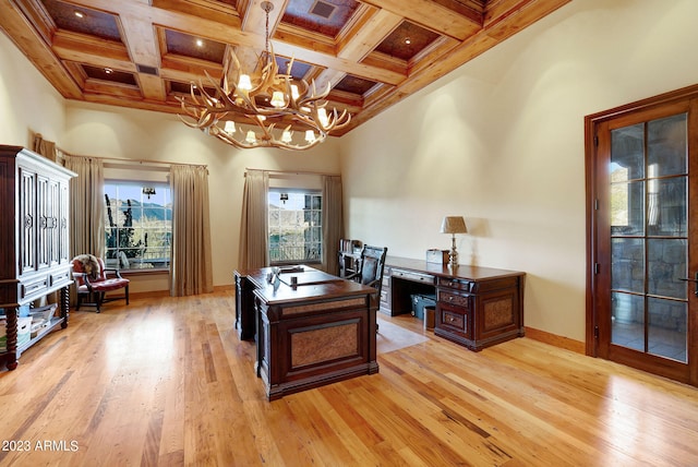 office featuring coffered ceiling, light hardwood / wood-style floors, beam ceiling, a high ceiling, and an inviting chandelier