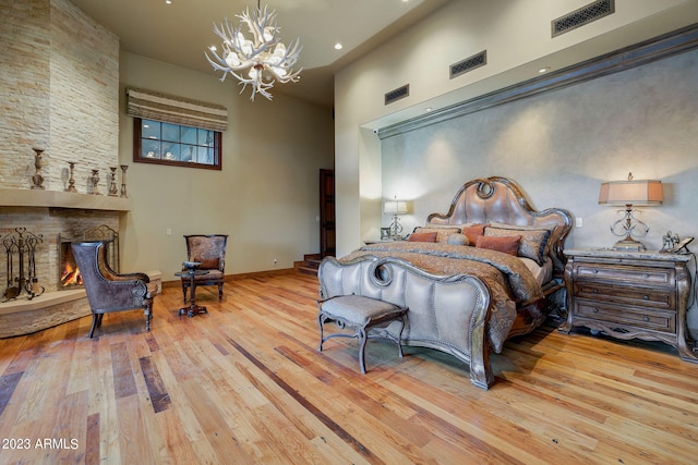 bedroom with a chandelier, a high ceiling, and light hardwood / wood-style flooring