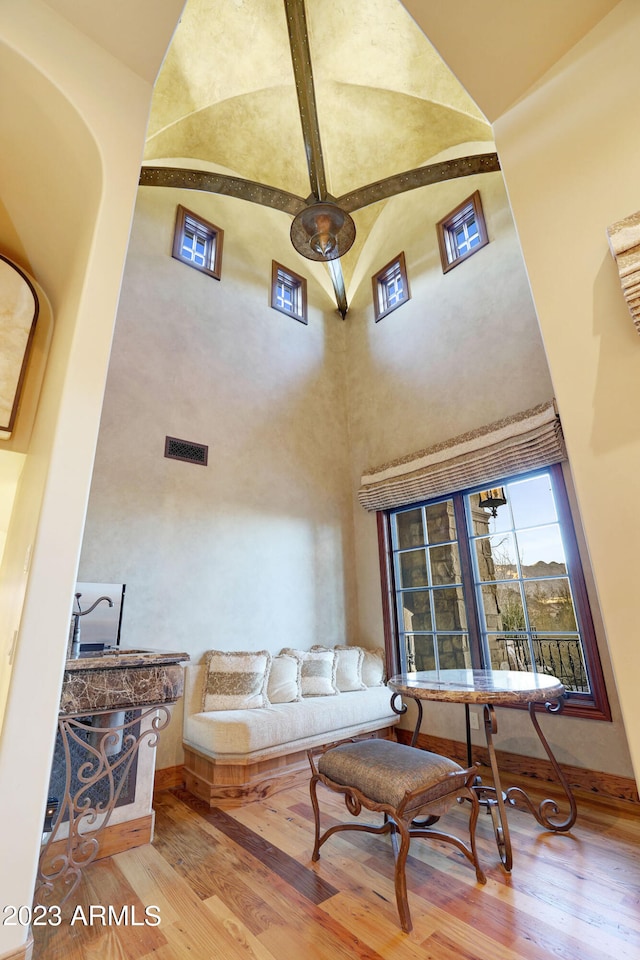 living room with high vaulted ceiling and light hardwood / wood-style floors