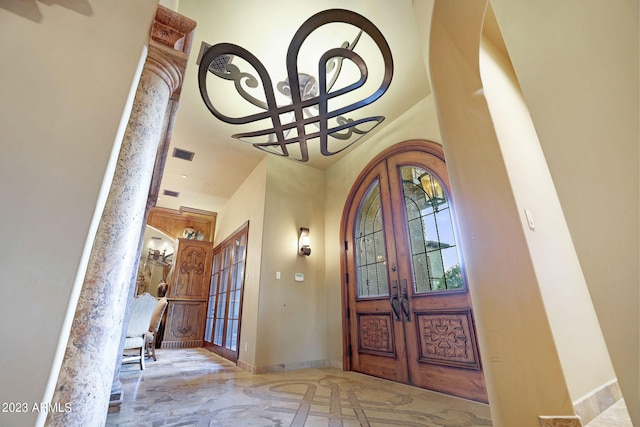 tiled entrance foyer with french doors and an inviting chandelier