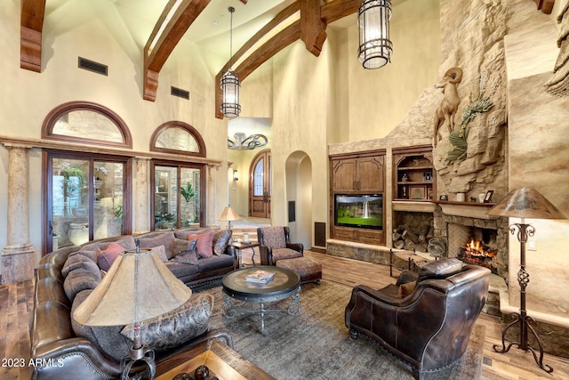 living room with high vaulted ceiling, a fireplace, beam ceiling, and hardwood / wood-style flooring