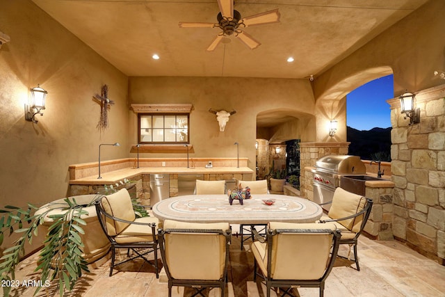 interior space with an outdoor kitchen, area for grilling, and ceiling fan