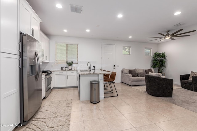 5897 N 195th Dr, Litchfield Park, AZ 85340 - kitchen featuring open floor plan, appliances with stainless steel finishes, a sink, a breakfast bar area, and ceiling fan
