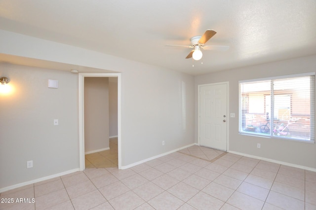 tiled spare room with ceiling fan