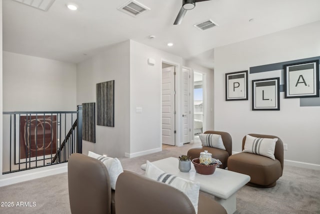 sitting room with ceiling fan and light colored carpet