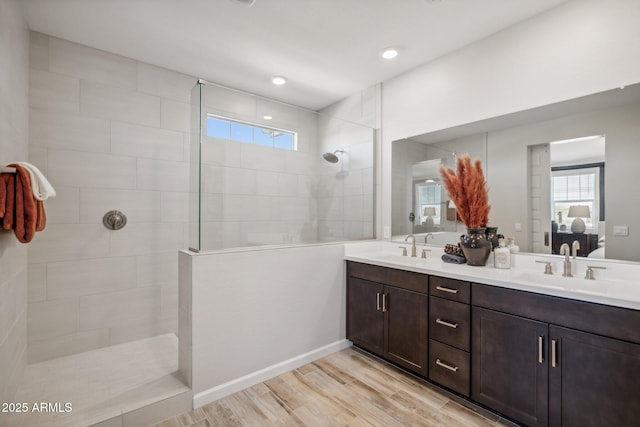 bathroom featuring vanity, hardwood / wood-style flooring, and a tile shower