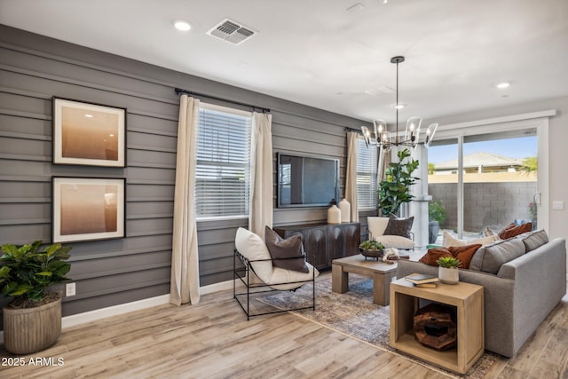 living room with light hardwood / wood-style floors and a chandelier