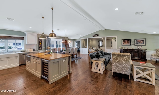 kitchen with dishwasher, beverage cooler, white cabinets, and a center island