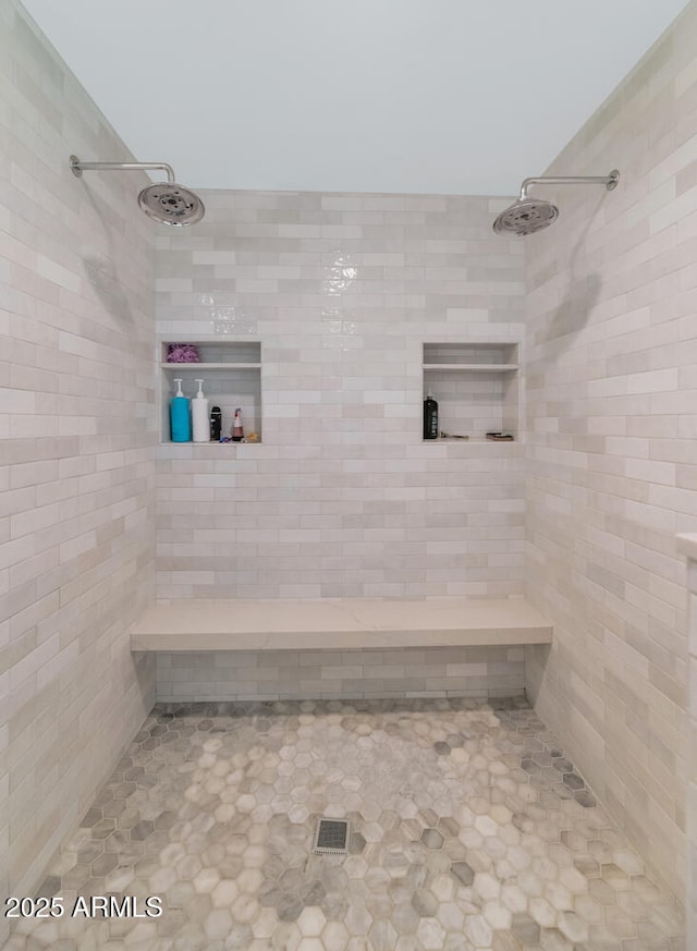 bathroom featuring tile patterned floors and a tile shower