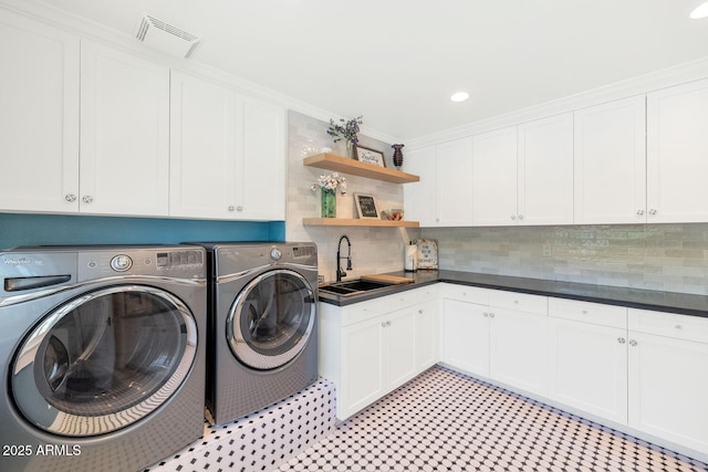 washroom with washer and dryer, sink, crown molding, and cabinets