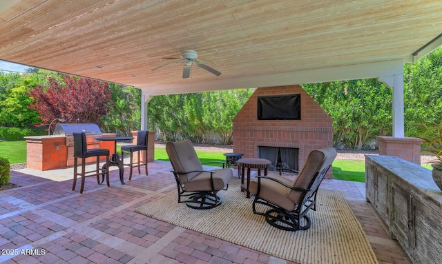 view of patio / terrace featuring an outdoor brick fireplace, an outdoor kitchen, and ceiling fan